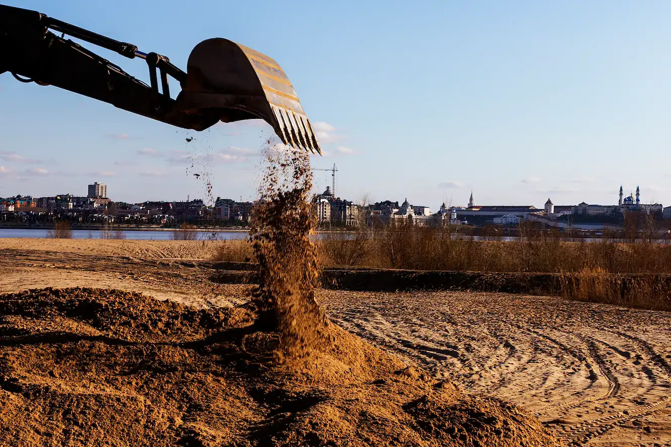 tractor-pours-the-gravel-from-the-bucket HTM France - Maintenance de matériel TP et agricole
